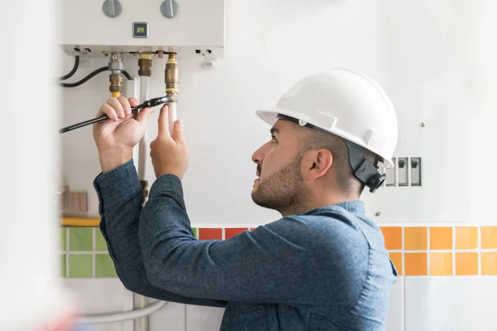 A technician installing gas water heaters using a wrench in Des Moines, IA